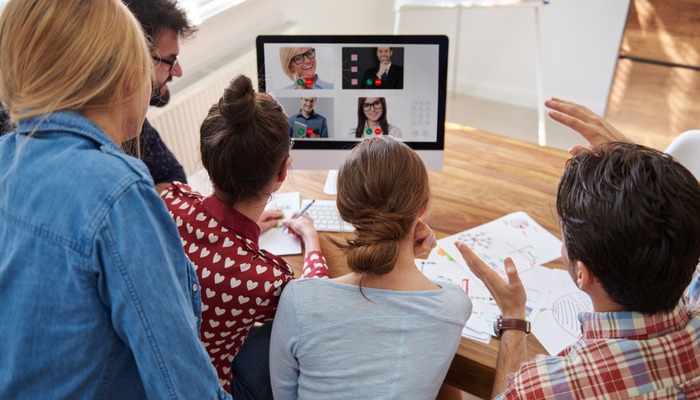 Office workers videoconferencing with remote workers