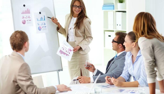 Woman giving a marketing presentation to a group of peers