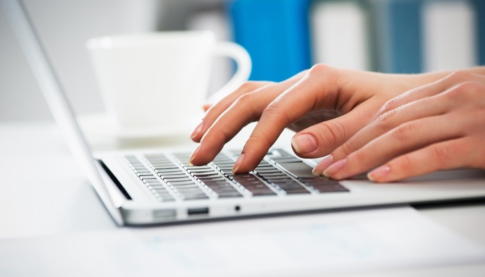 Closeup of businesswoman writing on a laptop