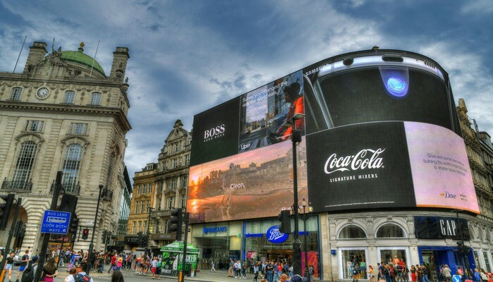 colorful dramatic HDR image of the famous Piccadilly Circus with its famous in the center of London on beautiful blue cloudy sky